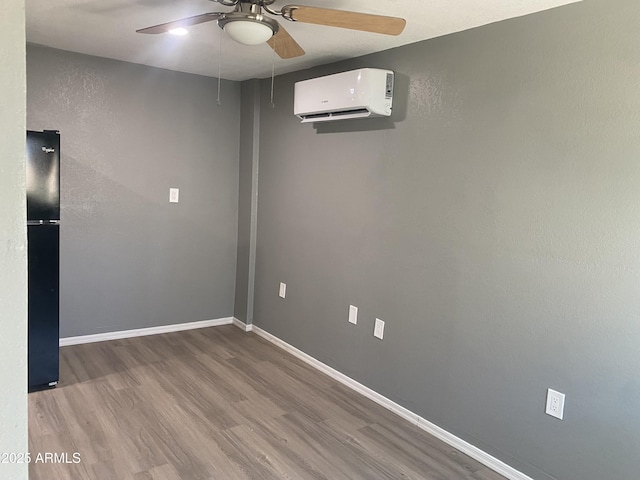 1217 E Hess Ave, Phoenix, AZ 85034 - unfurnished room with a wall unit AC, a ceiling fan, and wood finished floors