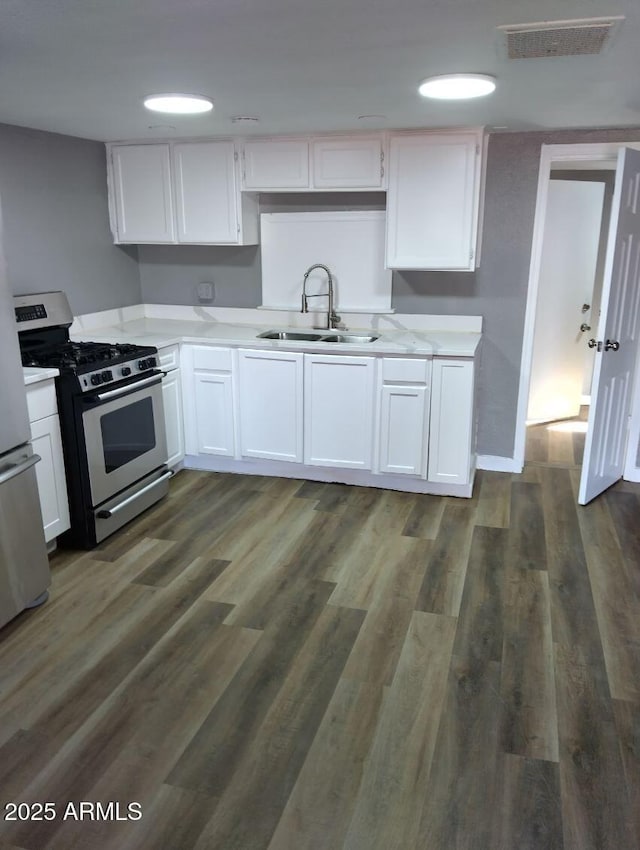 1217 E Hess Ave, Phoenix, AZ 85034 - kitchen with stainless steel appliances, white cabinets, light countertops, and dark wood-style flooring