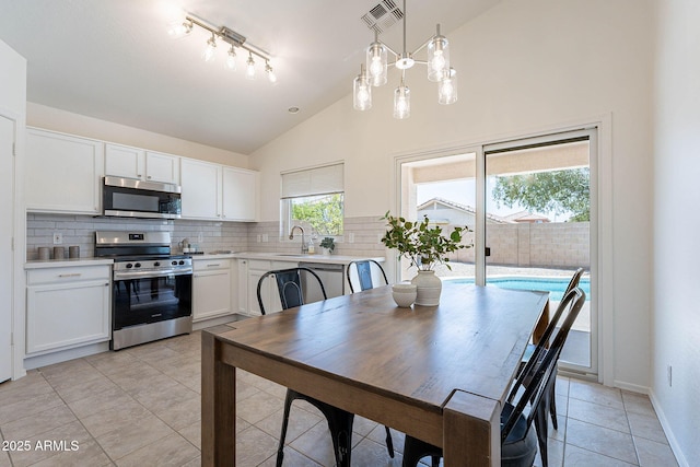 11805 W Sunnyside Dr, El Mirage, AZ 85335 - dining space featuring light tile patterned flooring, high vaulted ceiling, track lighting, and baseboards