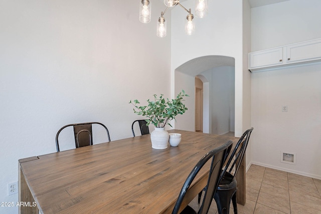11805 W Sunnyside Dr, El Mirage, AZ 85335 - dining space with arched walkways, light tile patterned flooring, and baseboards