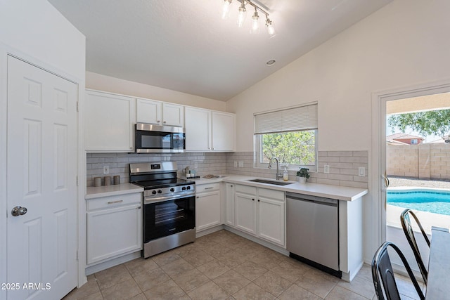 11805 W Sunnyside Dr, El Mirage, AZ 85335 - kitchen with stainless steel appliances, a sink, vaulted ceiling, plenty of natural light, and white cabinetry