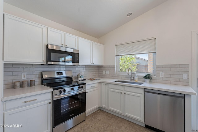 11805 W Sunnyside Dr, El Mirage, AZ 85335 - kitchen with stainless steel appliances, lofted ceiling, a sink, white cabinets, and backsplash