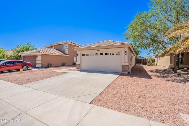 11805 W Sunnyside Dr, El Mirage, AZ 85335 - view of front of property with stucco siding, driveway, a garage, a tile roof, and stone siding