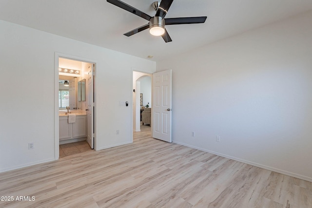 11805 W Sunnyside Dr, El Mirage, AZ 85335 - unfurnished bedroom with light wood-style floors, arched walkways, and baseboards
