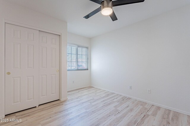 11805 W Sunnyside Dr, El Mirage, AZ 85335 - unfurnished bedroom with light wood-style floors, a closet, a ceiling fan, and baseboards