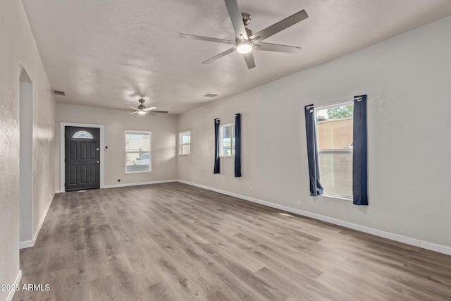 entryway with ceiling fan, light hardwood / wood-style floors, and a textured ceiling