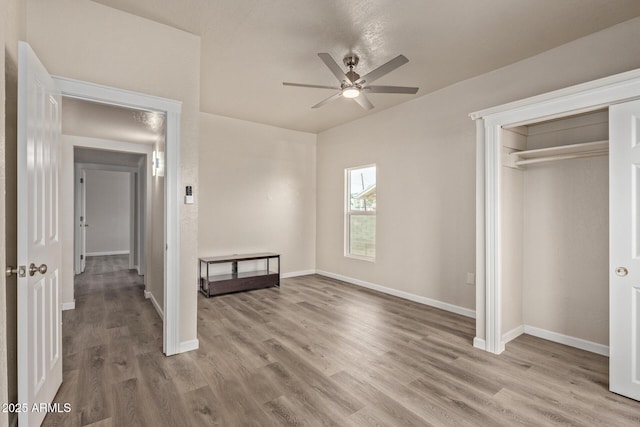 unfurnished bedroom featuring light wood-type flooring, ceiling fan, and a closet