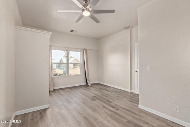 empty room with ceiling fan and light hardwood / wood-style flooring