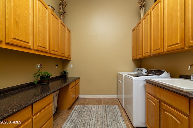 clothes washing area featuring separate washer and dryer, sink, cabinets, and dark tile patterned floors