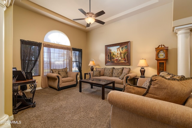 carpeted living room featuring ornate columns and ceiling fan