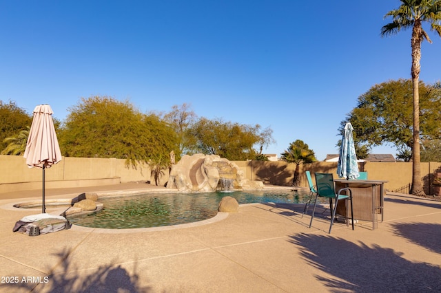 view of patio featuring pool water feature and a fenced in pool