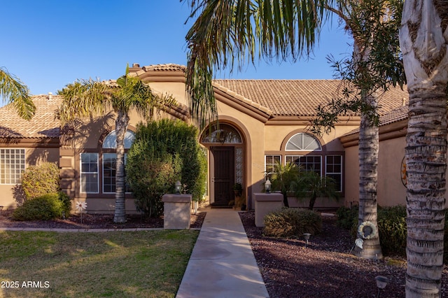 mediterranean / spanish-style home featuring a front yard