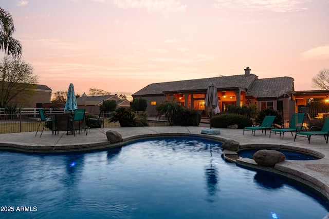 pool at dusk featuring a patio area