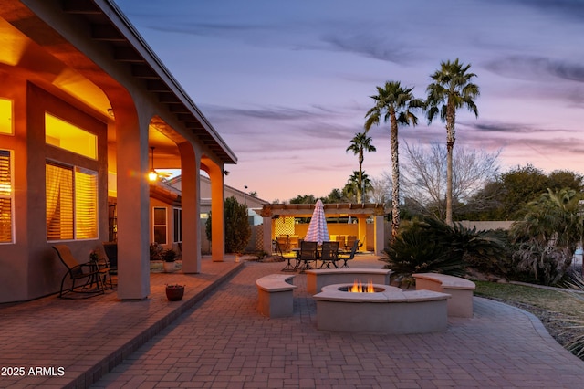 patio terrace at dusk featuring a fire pit