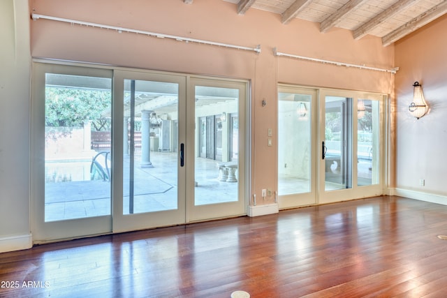 entryway with dark wood-type flooring, wooden ceiling, lofted ceiling with beams, and french doors