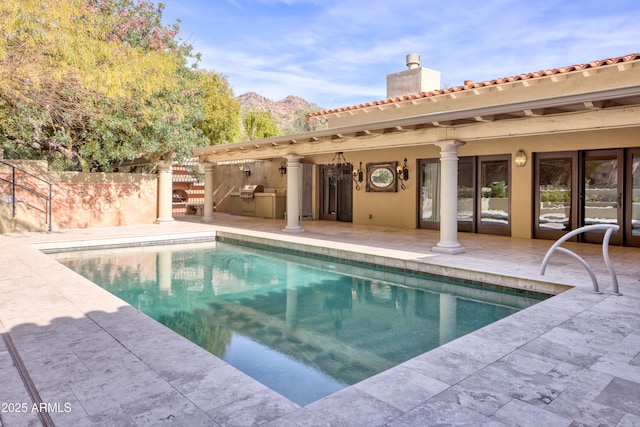 view of swimming pool featuring a patio area, area for grilling, a mountain view, and a grill