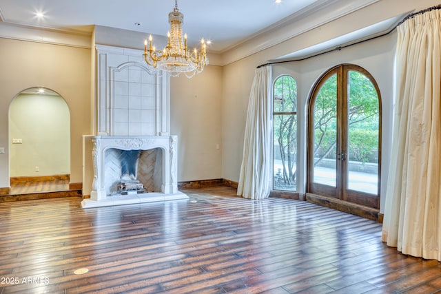 unfurnished living room featuring dark hardwood / wood-style floors, ornamental molding, and french doors