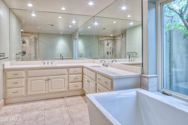 bathroom with tile patterned floors, vanity, and shower with separate bathtub