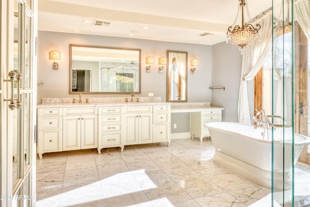 bathroom with a bath, a chandelier, and vanity