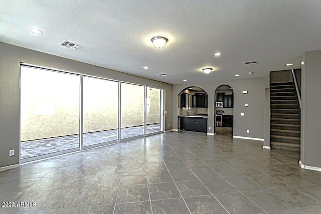 unfurnished living room featuring tile patterned flooring and a textured ceiling