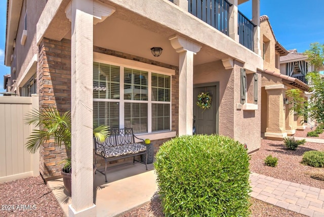 view of exterior entry featuring a balcony