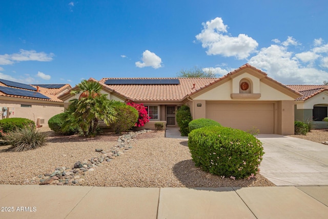 22319 N Desperado Dr, Sun City West, AZ 85375 - mediterranean / spanish home with concrete driveway, stucco siding, a tile roof, a garage, and roof mounted solar panels