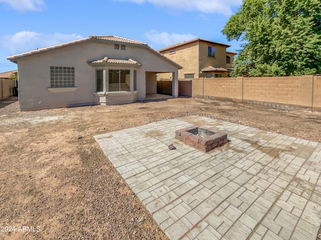 back of house with a patio area and a fire pit