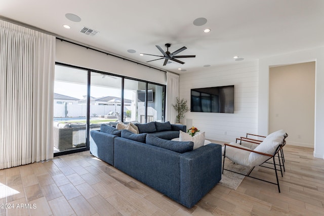 living room featuring light hardwood / wood-style flooring and ceiling fan