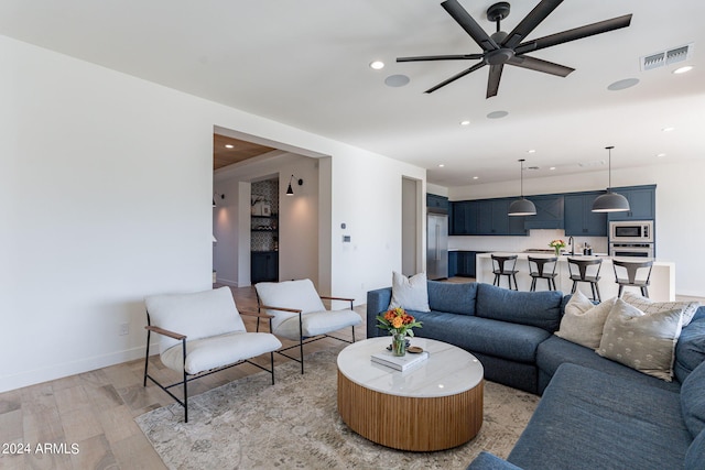 living room with ceiling fan and light hardwood / wood-style floors