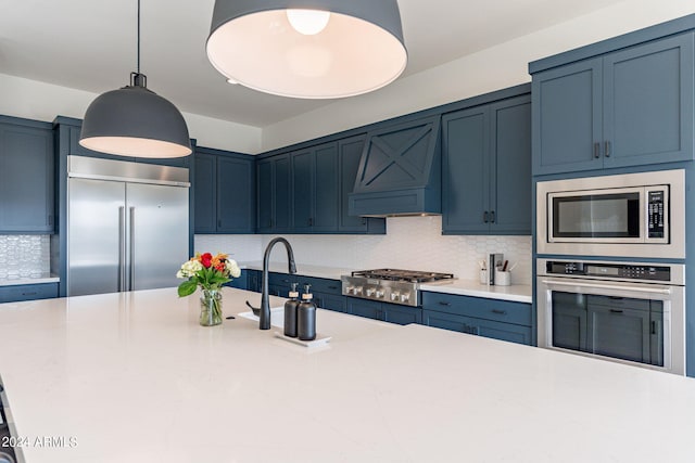 kitchen with blue cabinetry, backsplash, and built in appliances