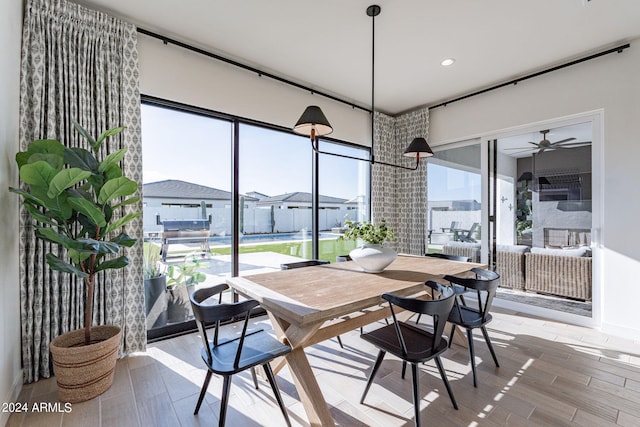 dining area with light wood-type flooring, ceiling fan, and a wealth of natural light