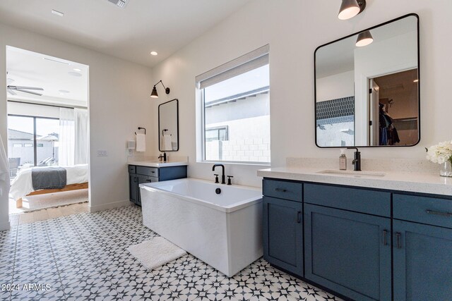 bathroom featuring ceiling fan, vanity, and a bath