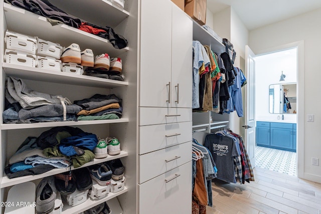 walk in closet with light wood-type flooring and sink