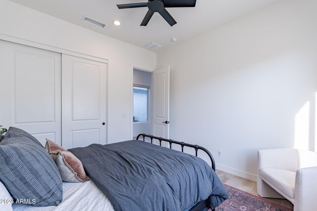 bedroom with a closet, ceiling fan, and light wood-type flooring