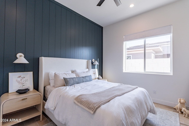 bedroom featuring wooden walls, ceiling fan, and hardwood / wood-style flooring