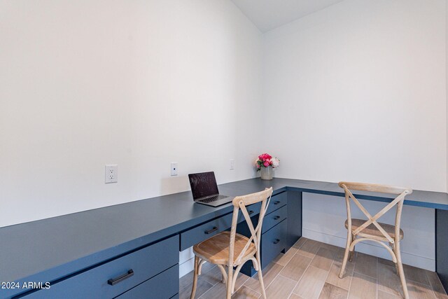 office space with built in desk and light hardwood / wood-style floors