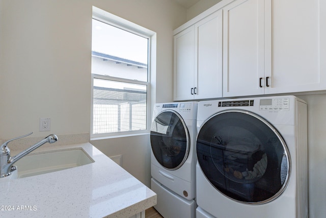 laundry area with cabinets, sink, and washing machine and dryer