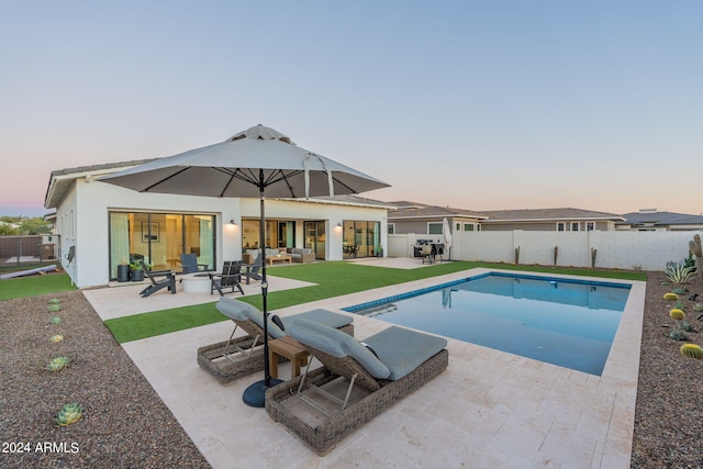 pool at dusk featuring a patio area