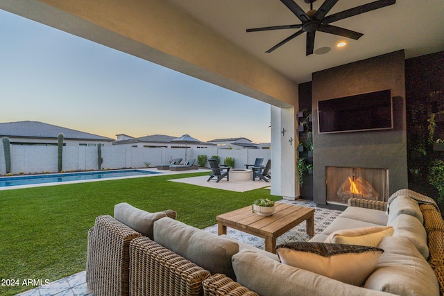 view of patio / terrace with ceiling fan, a fenced in pool, and an outdoor living space with a fireplace