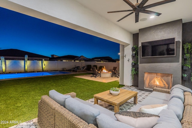 view of patio / terrace featuring ceiling fan, a fenced in pool, and an outdoor living space with a fire pit