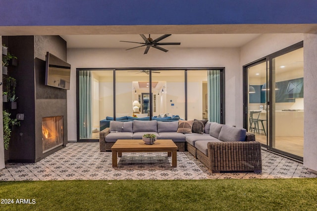 carpeted living room with ceiling fan and a fireplace