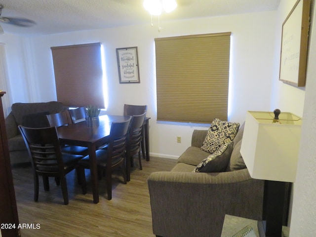 dining room with ceiling fan, a textured ceiling, and hardwood / wood-style floors