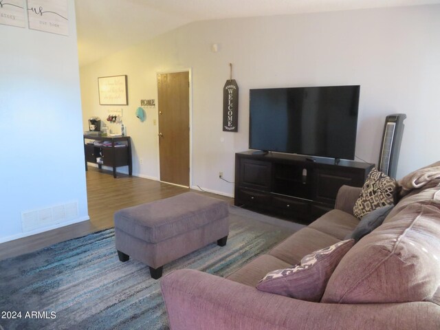 living room featuring lofted ceiling and hardwood / wood-style flooring