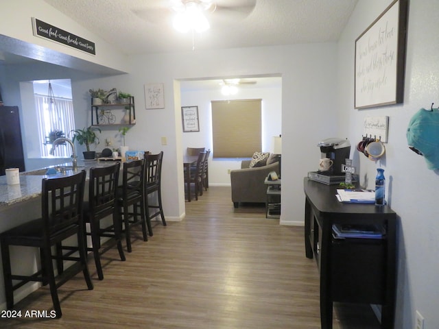 dining room with ceiling fan, a textured ceiling, and hardwood / wood-style floors