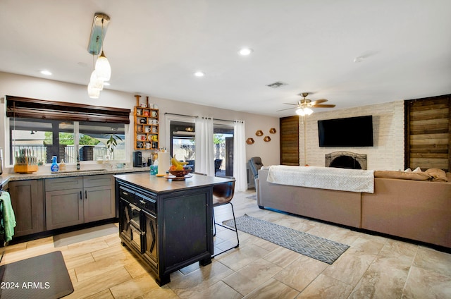 kitchen with a center island, a kitchen bar, a healthy amount of sunlight, and a brick fireplace