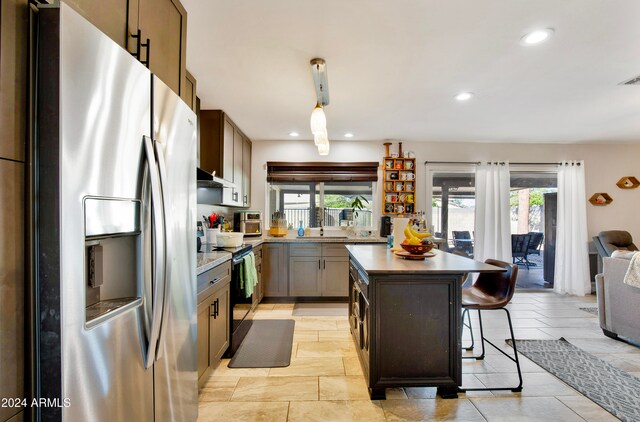 kitchen featuring a center island, hanging light fixtures, stainless steel appliances, and plenty of natural light