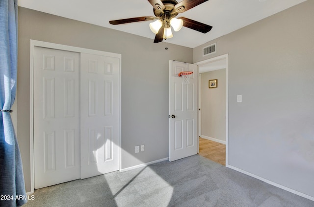 carpeted bedroom featuring a closet and ceiling fan