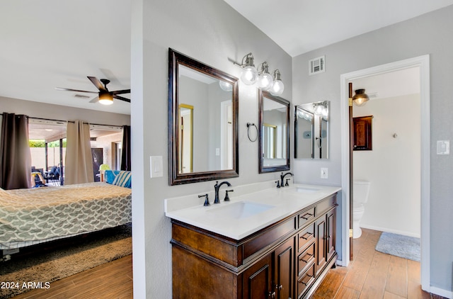 bathroom with toilet, vanity, wood-type flooring, and ceiling fan