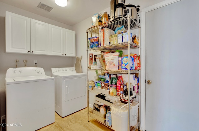 laundry area with washer and dryer and cabinets