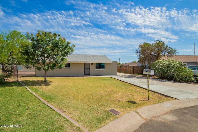 ranch-style home featuring fence, stucco siding, concrete driveway, and a front yard